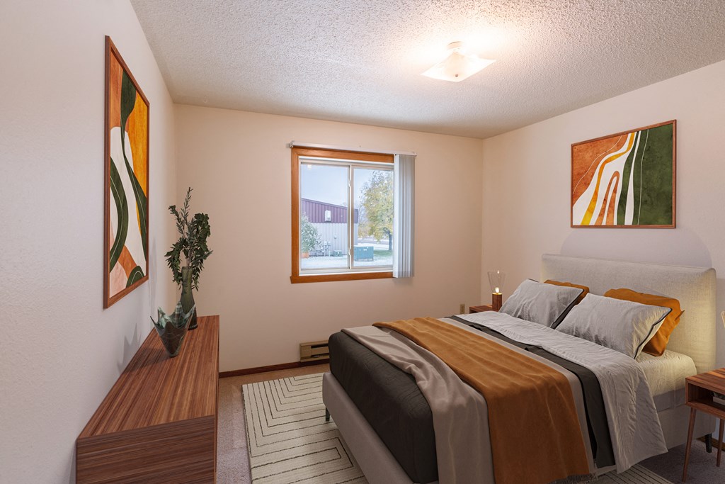 a bedroom with a bed and a window. Fargo, ND Huntington Apartments