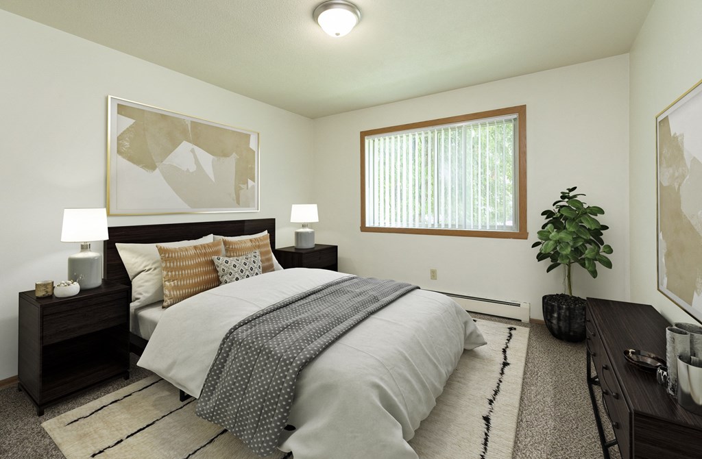 Fargo, ND Islander Apartments. A bedrooom with dark wood furnishings such as a bed, night stands, and a dresser. A window brightens the room with natural light