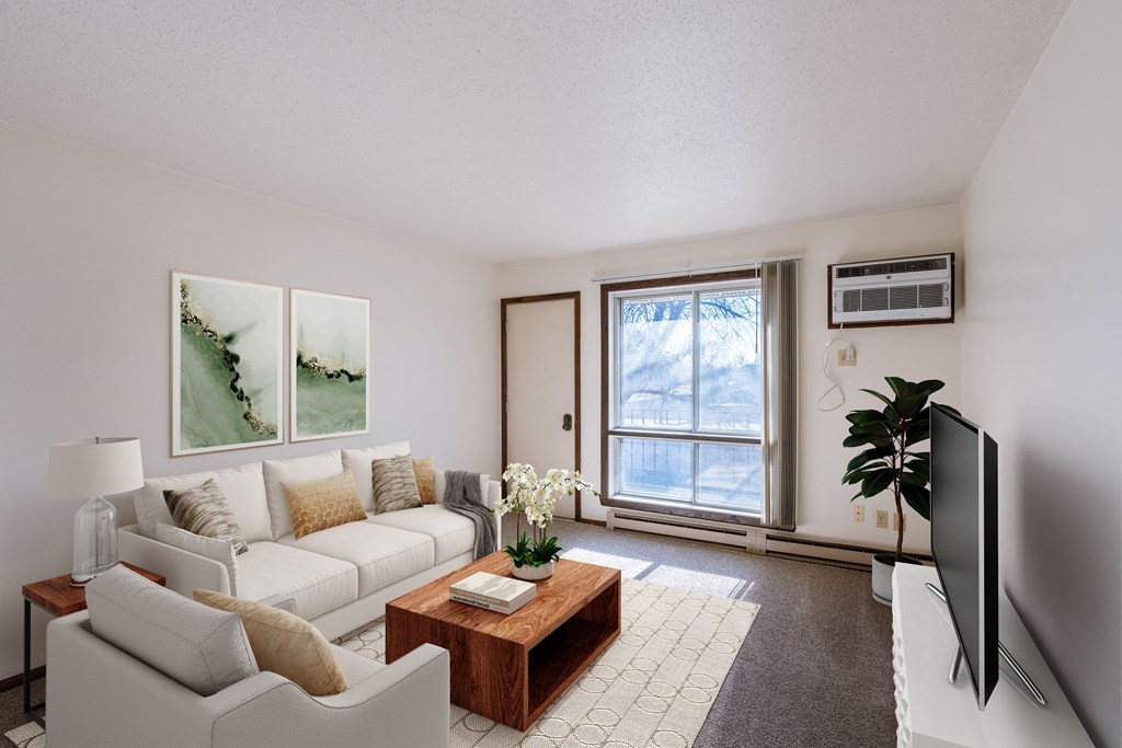 a living room with a white couch and a coffee table. Fargo, ND Jadestone Apartments