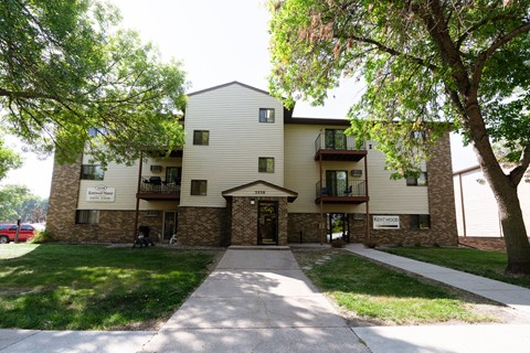 an apartment building with a sidewalk and trees