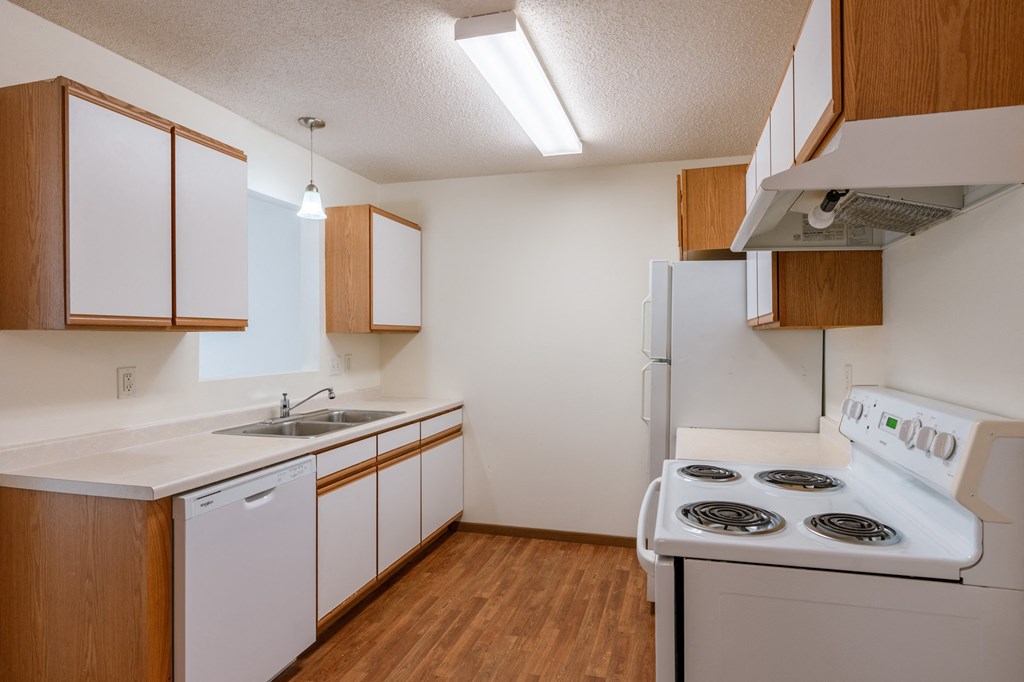 a kitchen with stove and sink. Fargo, ND Lake Crest Apartments