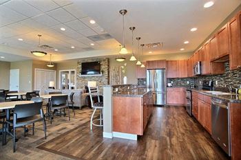 Fargo, ND Lake Crest Apartments. A kitchen with a stove top oven next to a refrigerator