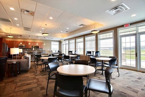 Fargo, ND Lake Crest Apartments. A large room with tables and chairs and a kitchen in the background