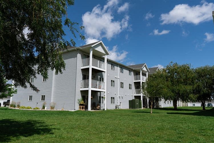 Fargo, ND Lake Crest Apartments | Exteior Fargo, ND Lake Crest Apartments. A large apartment complex with a grassy area in front of it