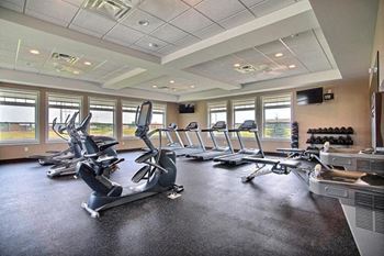 Fargo, ND Lake Crest Apartments. A room filled with lots of cardio equipment and a flat screen tv