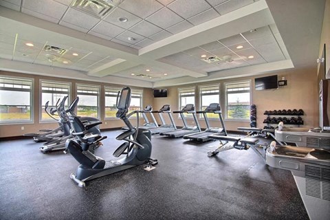 Fargo, ND Lake Crest Apartments. A room filled with lots of cardio equipment and a flat screen tv