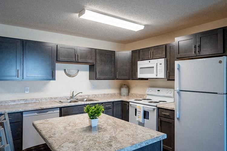 Fargo, ND Lake Crest Apartments | Kitchen Fargo, ND Lake Crest Apartments. A kitchen with a white stove top oven next to a refrigerator