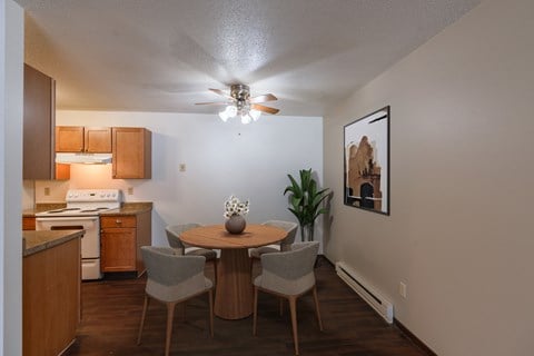 a dining area with a table and chairs and a ceiling fan. Fargo, ND Long Island Apartments