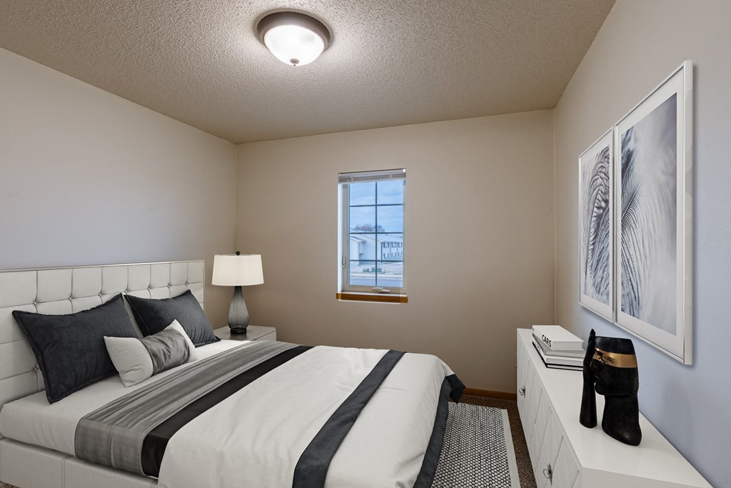 a bedroom with a large bed and a window. Moorhead, MN Townhomes at Mallard Creek