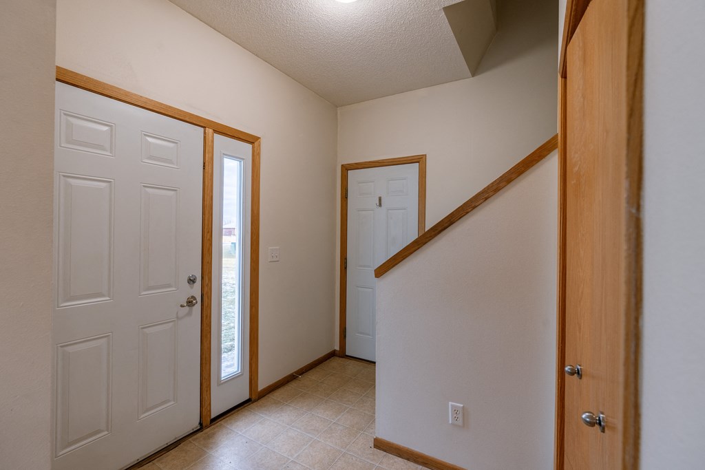 an entry door with a closet and door to the garage. Moorhead, MN Mallard Creek Apartments