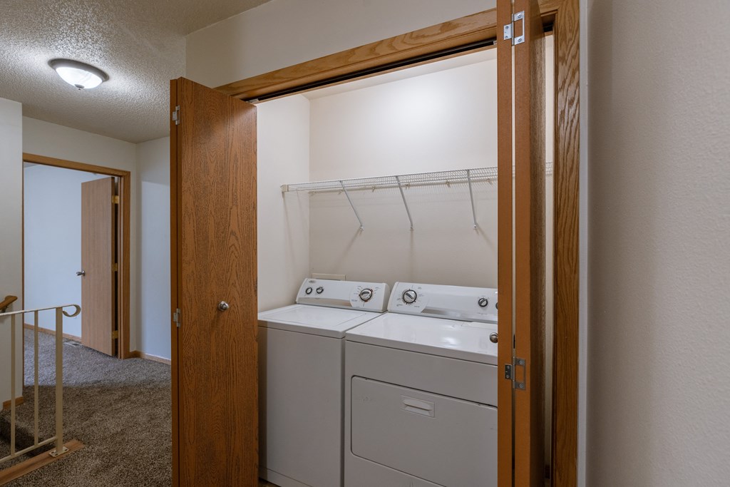 a laundry closet on the second floor of a townhome with a washer and dryer. Moorhead, MN Mallard Creek Apartments