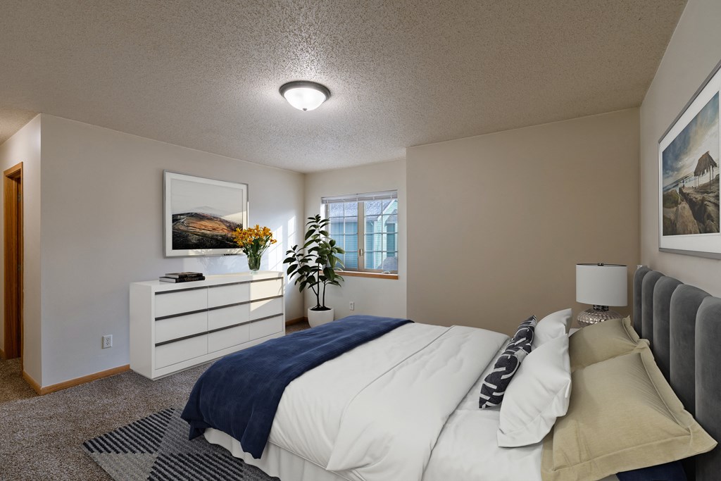 a bedroom with a bed and a dresser and a window. Moorhead, MN Townhomes at Mallard Creek