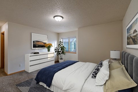 Moorhead, MN Townhomes at Mallard Creek | Bedroom a bedroom with a bed and a dresser and a window. Moorhead, MN Townhomes at Mallard Creek