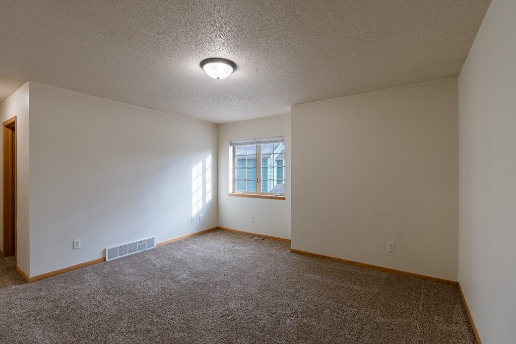 a bedroom with a window and closet. Moorhead, MN Mallard Creek Apartments