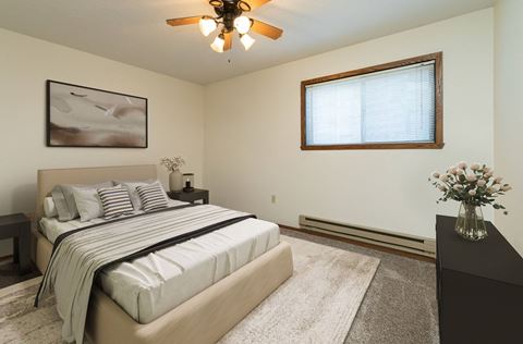 a bedroom with a bed and a ceiling fan. Fargo, ND Maplewood Bend Apartments