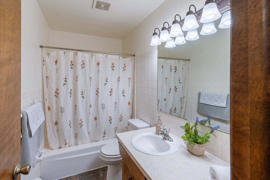 a bathroom with a sink and a toilet and a tub. Fargo, ND Martha Alice Apartments