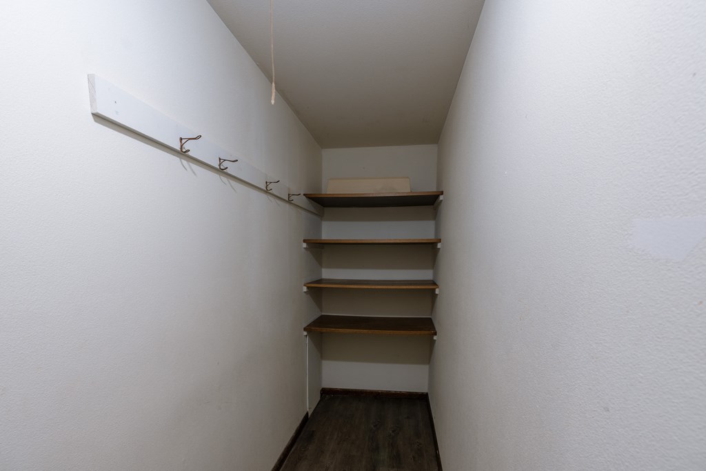 a small closet in a room with shelves and a white wall. Fargo, ND Martha Alice Apartments