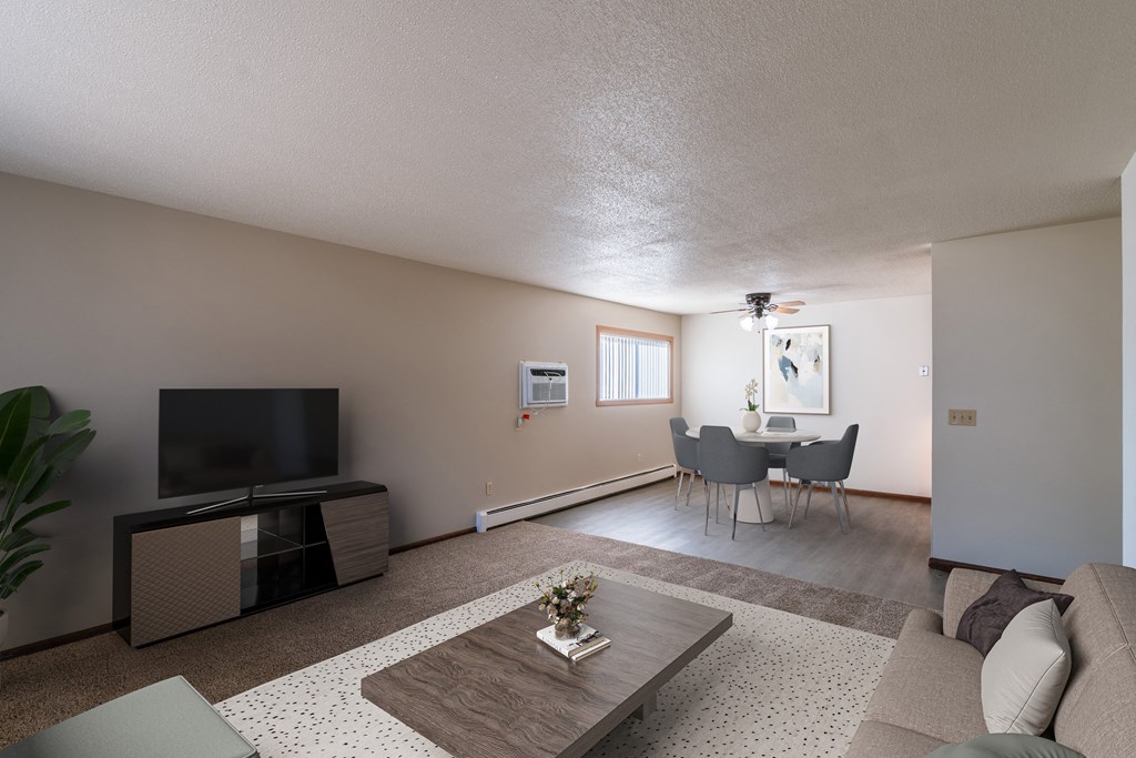 a living room with a couch and a table and a tv. Fargo, ND Martha Alice Apartments