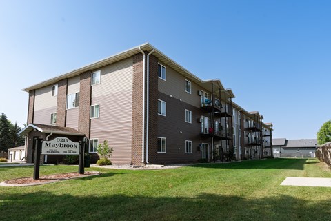 a large apartment building with a sign in front of it. Fargo, ND Maybrook Apartments