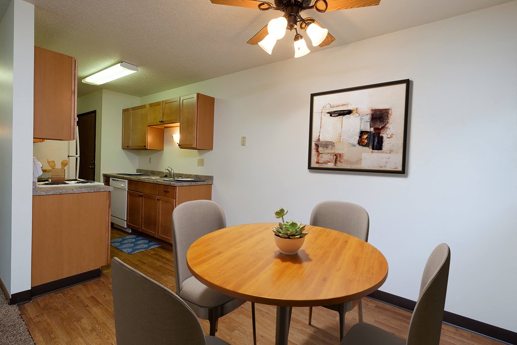 Fargo, ND Monticello. A dining area with a table and chairs and a kitchen in the background
