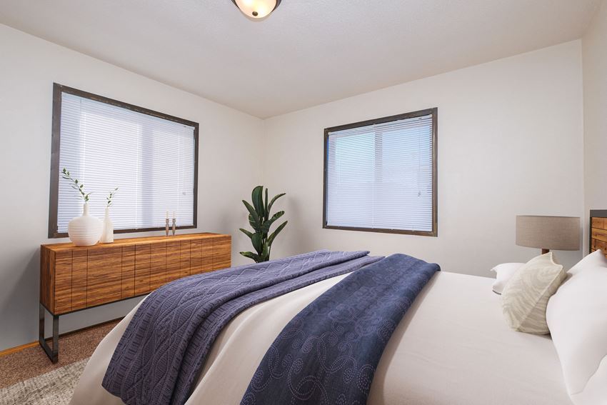 Fargo, ND Morningside Apartments. A bedroom with a large bed and two windows brighten the room - Photo Gallery