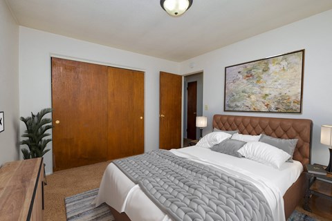 a bedroom with a large bed and a painting on the wall
