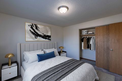 a bedroom with a bed and a closet. Fargo, ND North Manor Apartments
