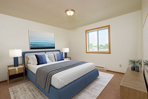 Bedroom with a blue and white bed and a window, Oak Court Apartments , ND  58103