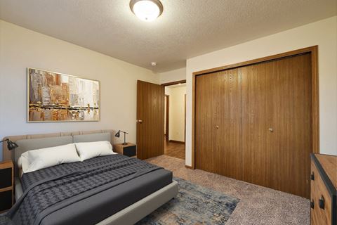 Fargo, ND Oxford Apartments. a bedroom with a bed and a wardrobe