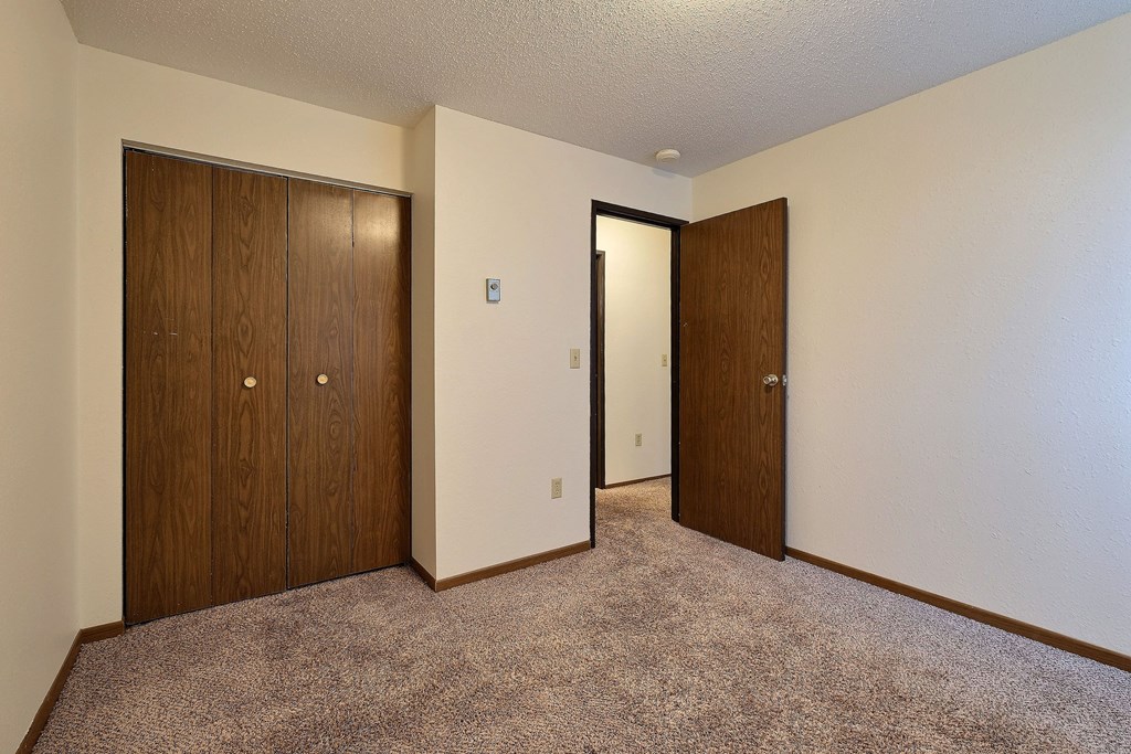 an empty room with two doors and a door to a closet. Fargo, Pacific Park II Apartments