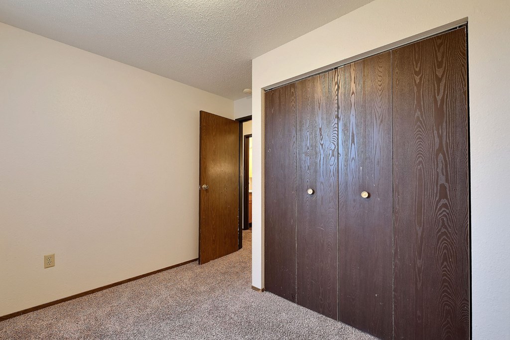 a bedroom with two closets and a door to a hallway. Fargo, Pacific Park II Apartments