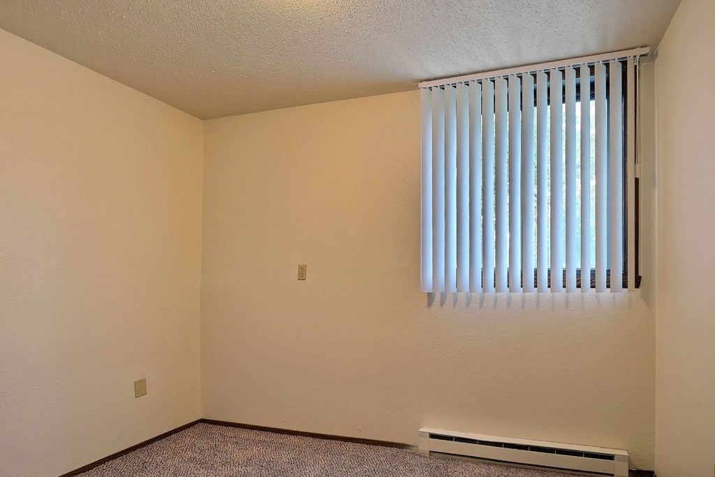an empty room with a window and a radiator. Fargo, Pacific Park II Apartments