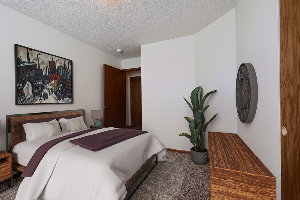 a bedroom with a bed and a potted plant. Fargo, ND Park Place Apartments