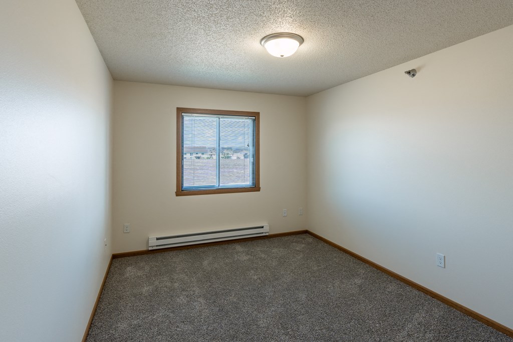 Fargo, ND Parkside Apartments. A bedroom with a window and carpet
