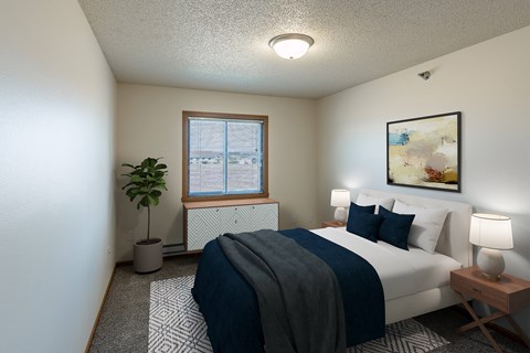 Fargo, ND Parkside Apartments. A bedroom with a large bed and a potted plant