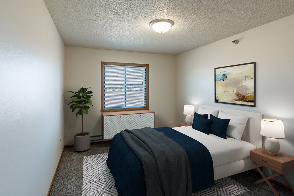 Fargo, ND Parkside Apartments | Bedroom Fargo, ND Parkside Apartments. A bedroom with a large bed and a potted plant