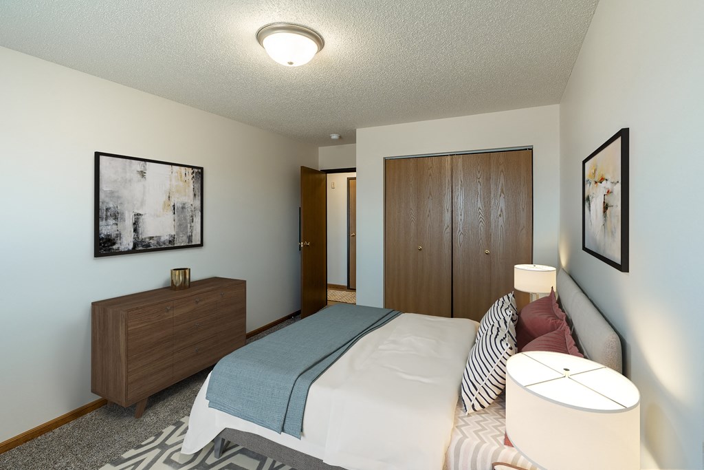 Fargo, ND Parkside Apartments. A bedroom with a bed and a dresser