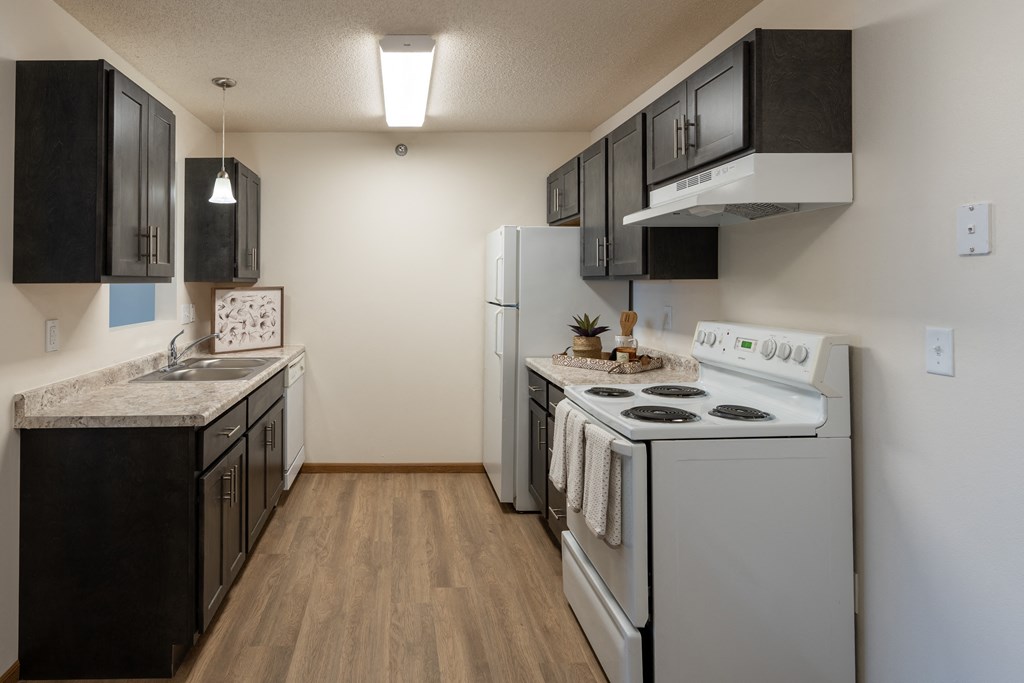 Fargo, ND Parkside Apartments |Kitchen Fargo, ND Parkside Apartments. A kitchen with white appliances and black cabinets