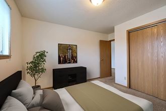 Fargo, ND Parkwest Gardens Apartments.  a bedroom with a bed and a dresser in a room