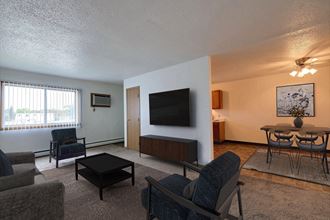 Fargo, ND Parkwest Gardens Apartments. a living room filled with furniture and a flat screen tv