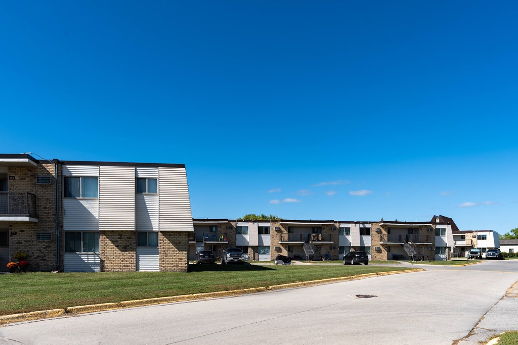 Apartment buildings on a street with a blue sky in the background at Parkwest Gardens West Fargo
