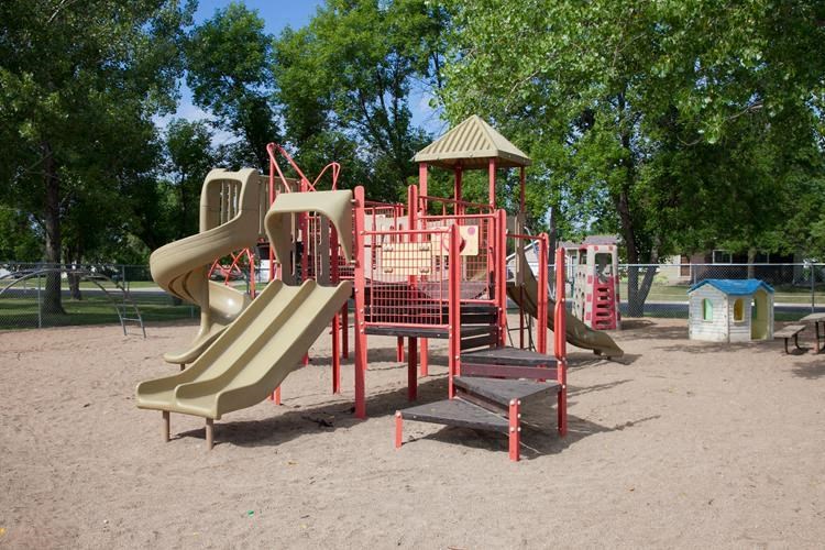 a playground with several slides and a gazebo