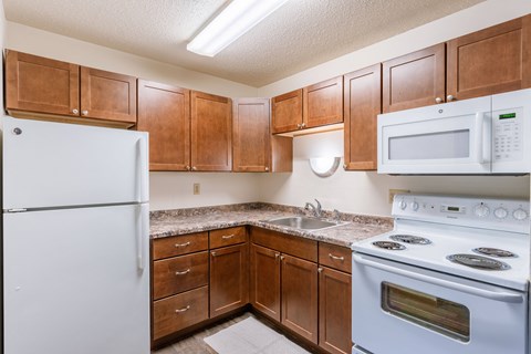 a kitchen with white appliances and wooden cabinets