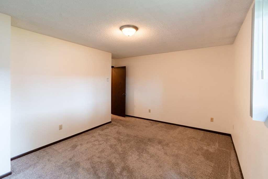 Fargo, ND Patricia Ann Apartments. A bedroom with a carpeted floor and white walls