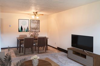 a living room and dining room with a table and a television. Fargo, ND Patricia Ann Apartments