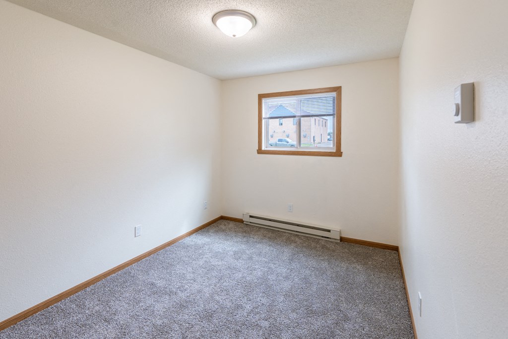 Fargo, ND Patricia Ann Apartments. A bedroom with white walls and carpet