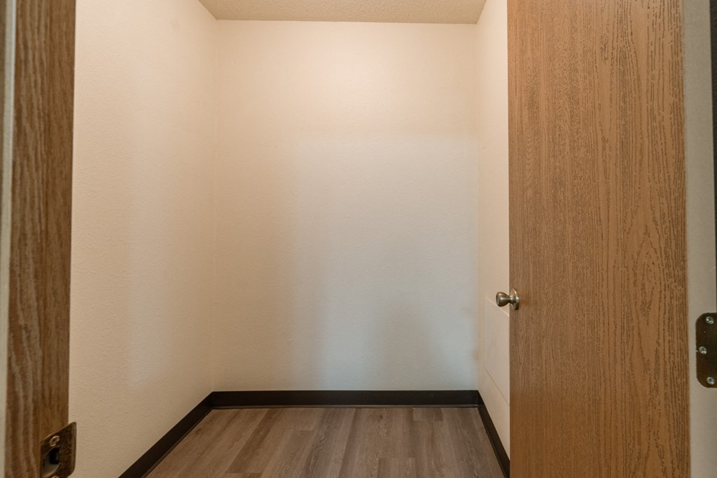 Fargo, ND Patricia Ann Apartments. A small room with a wooden door and hardwood floors