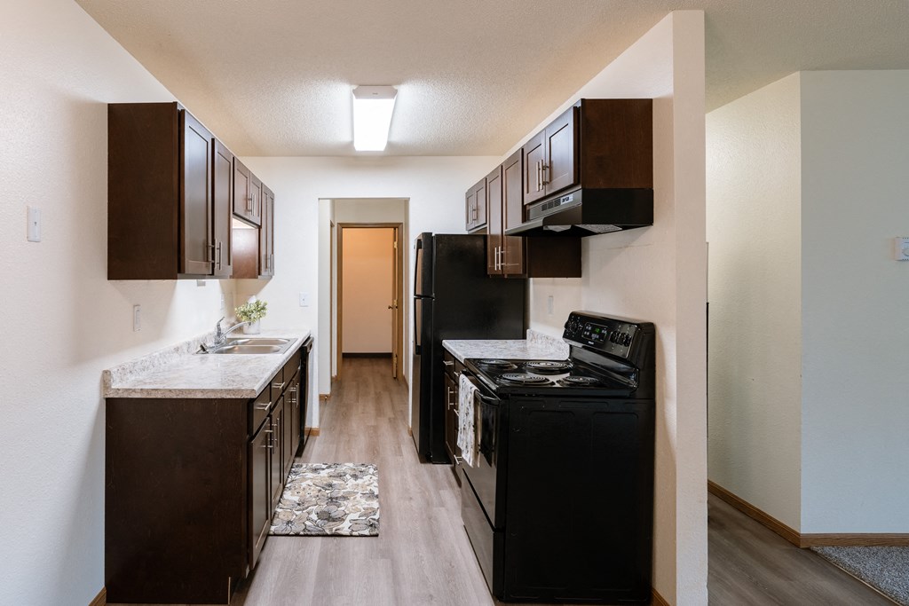 Fargo, ND Patricia Ann Apartments. A kitchen with black appliances and white countertops
