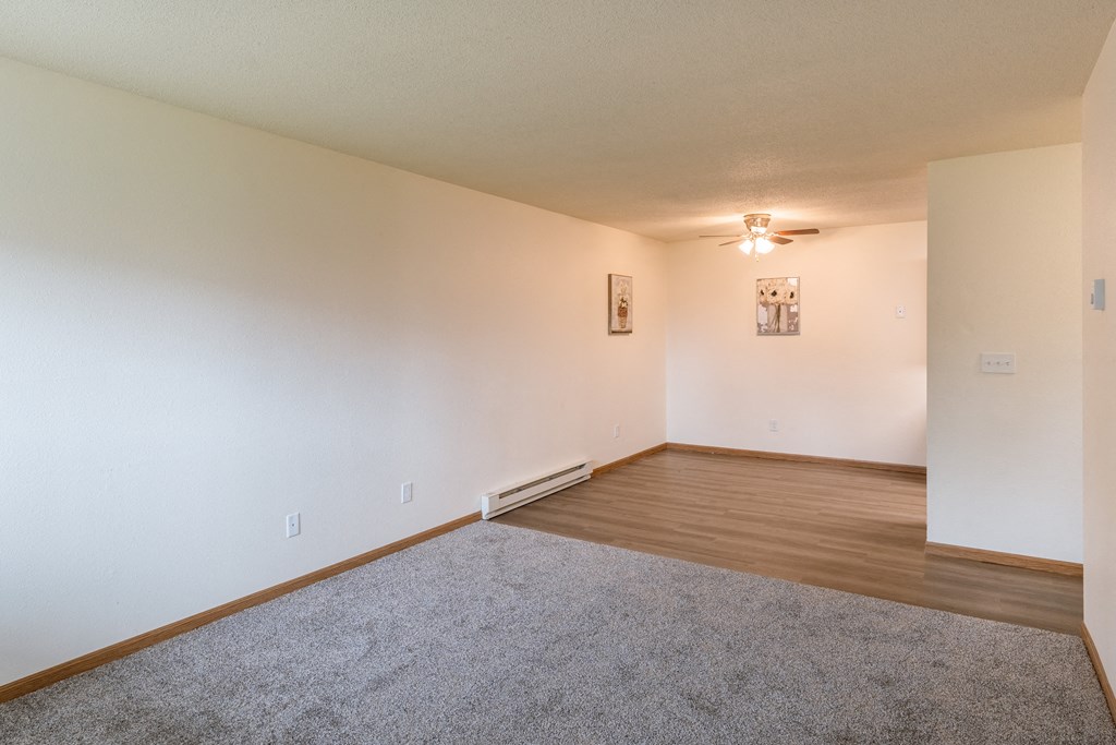 Fargo, ND Patricia Ann Apartments. A living room and dining room with a ceiling fan in the dining room.