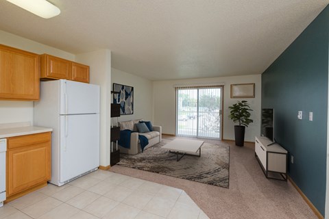 a kitchen and living room with a refrigerator and a sliding glass door